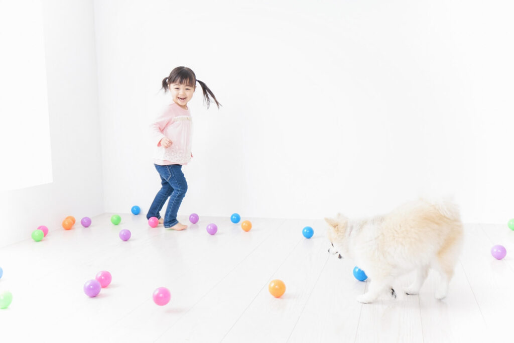 冬の季節に室内でボール遊びをする子供